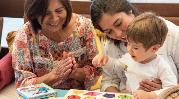 Family share puzzle with toddler.