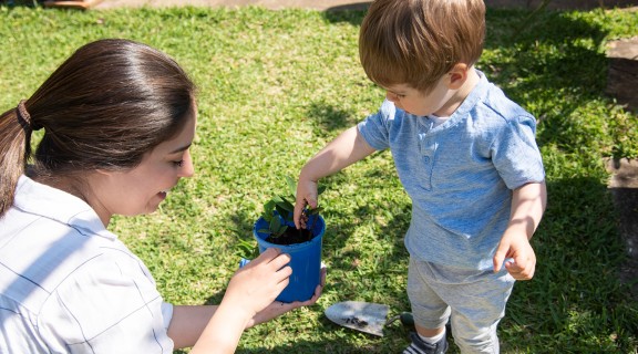 Child playing gardening with a woman