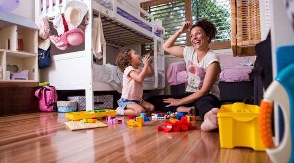 Mother and daughter playing together in child's room