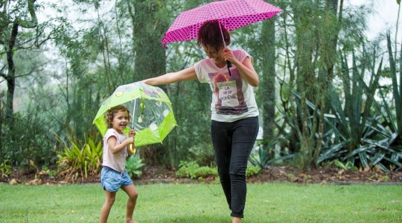 Mother and daughter playing in rain