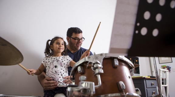 Adult and child playing the drums