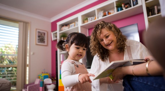 Mother and child sharing board book