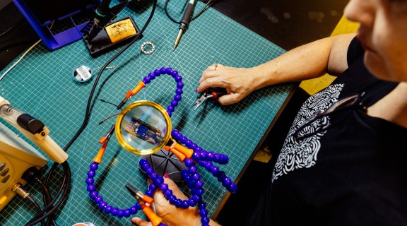 Someone soldering at an electronics bench