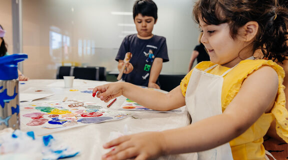Child paints at a Holiday fun event
