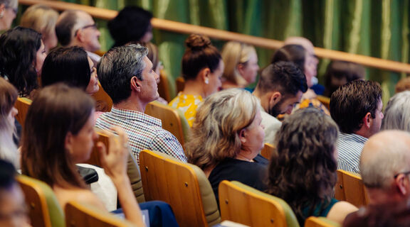 Audience seated in auditorium seats.