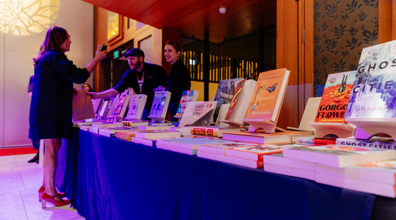 People selling and browsing at a table of books