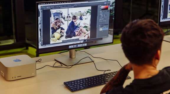 A person using photoshop on the Mac studio computer at the DML in The Edge.