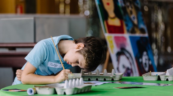 Child painting portrait in workshop, Joe Ruckli, 2021