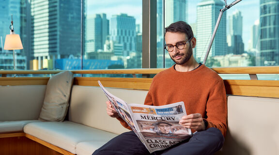 Man reading newspaper at the library