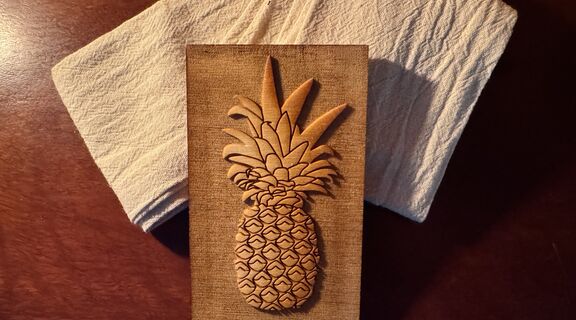 Pineapple block print sits against a piece of fabric on a flat lay on the table