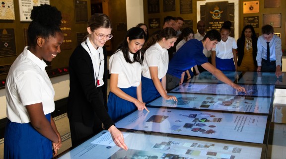 Group of students interacting with touch screens at Anzac Square Memorial Galleries