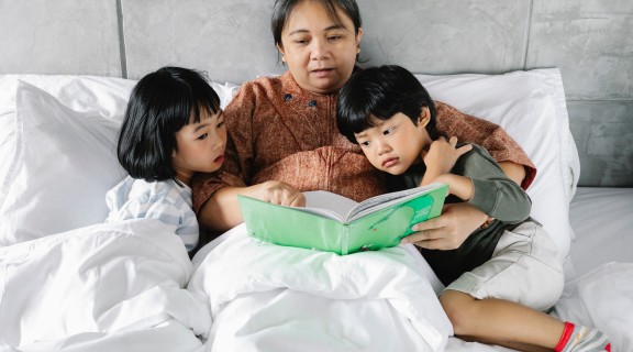 Grandparent reading a bedtime story to two children