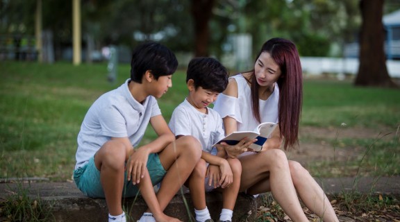 Family reading together outside