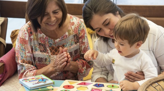 Two women playing games with child