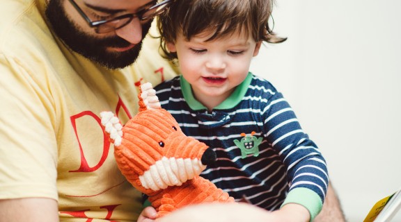 Dad with his toddler son reading a book