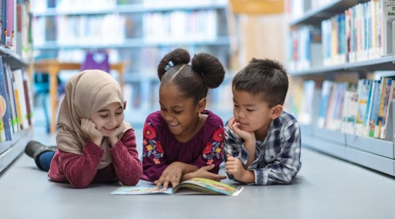 Three Children in Library Aisle