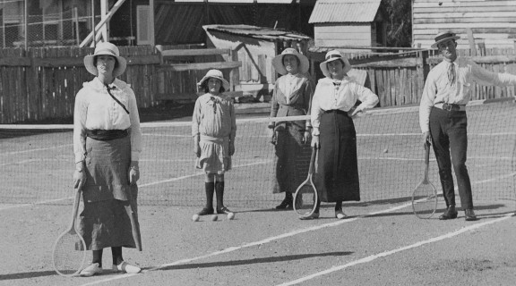 Tennis players standing on a tennis court, ca. 1915