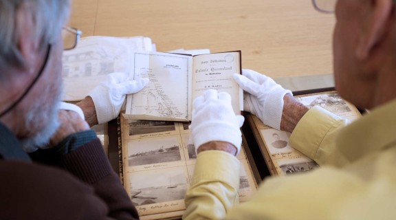 Men viewing collection items at the State Library.
