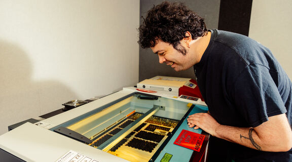 Man looks at laser cutter