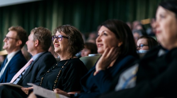 Row of people seated in an auditorium looking upwards.