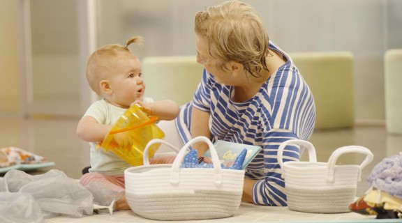 Baby and woman playing together on the floor.