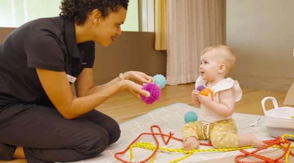 Woman and young child playing with colourful balls.