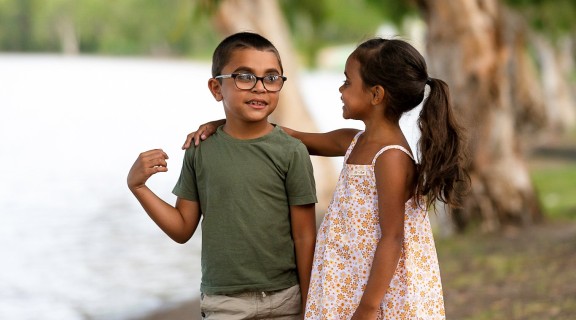 Boy and girls standing together by water