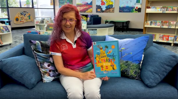 Librarian reading a book at a story time session