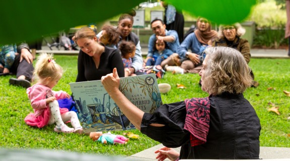 Vicki reading story book to families