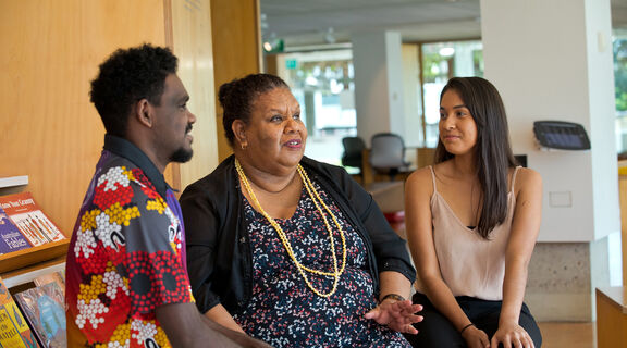 Two young people and an older woman chatting. 