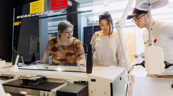 People learning to use the laser cutter