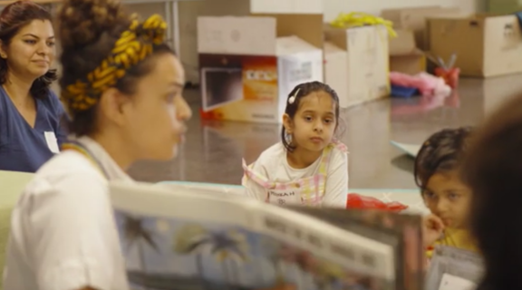 An early childhood educator reads where the wild things are to children