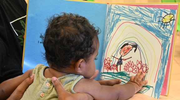 child pointing at page in book, My People