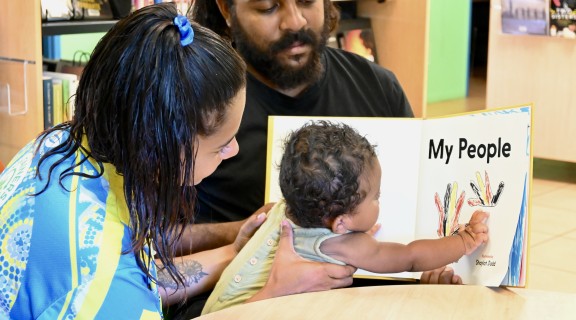 Parents and baby reading My People