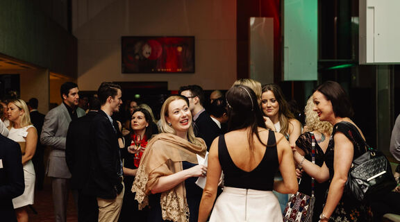 Group of people chatting at a social event at State Library. 