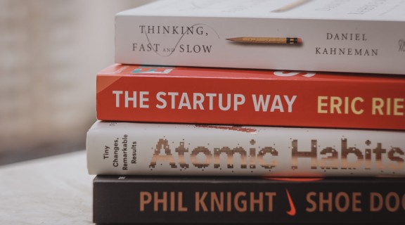 A stack of four business books