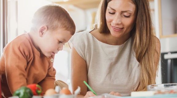 Child and adult writing letters together