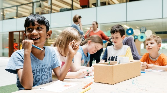 Kids working around a table at the Summer Festival, State Library Queensland