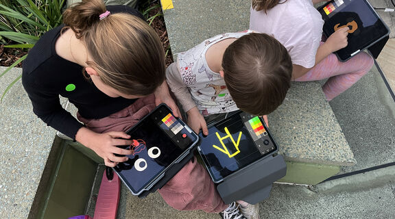 A photo of two children animating on an ipad
