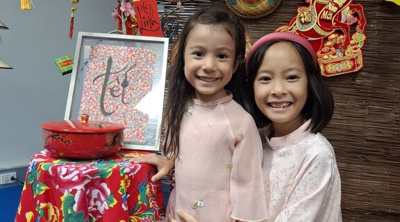 Two young girls hug at Tet celebration
