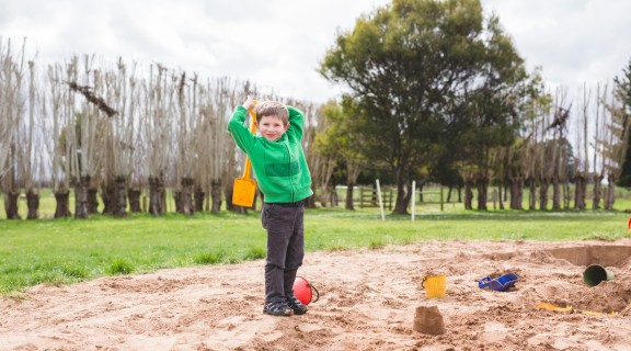 Boy in jumper playing in sandpit