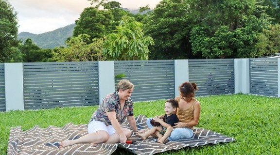 Women and child on a rug in backyard