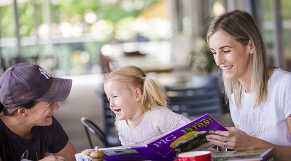 Parents and preschooler sitting at a table at a cafe