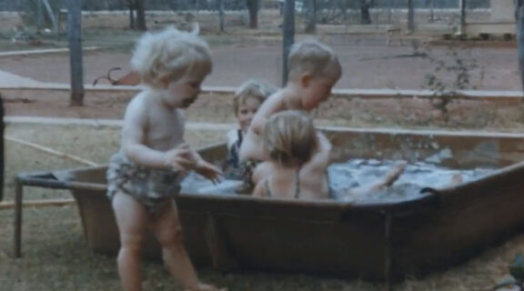 Four toddlers playing in water outside