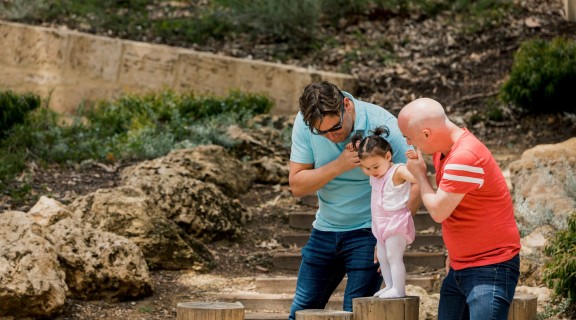 Parents helping child to balance