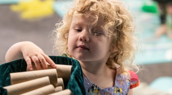 Child playing with basket of cardboard rolls, 13 May 2022, Photographer Josie Huang, State Library of Queensland