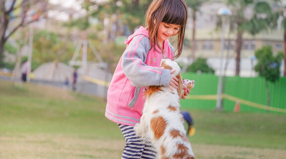 Young girl playing with her pet dog outside