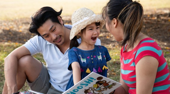 Family reading Shoosh! in the park