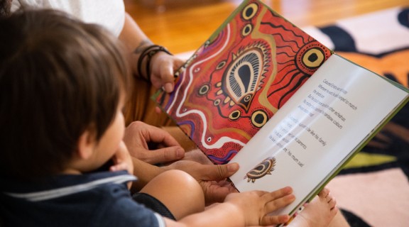 Family reading a book called The Coloured Echidna