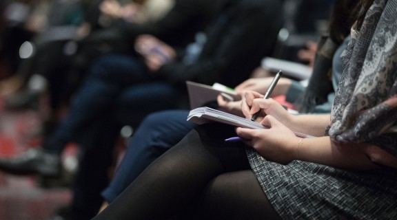 Audience member taking notes